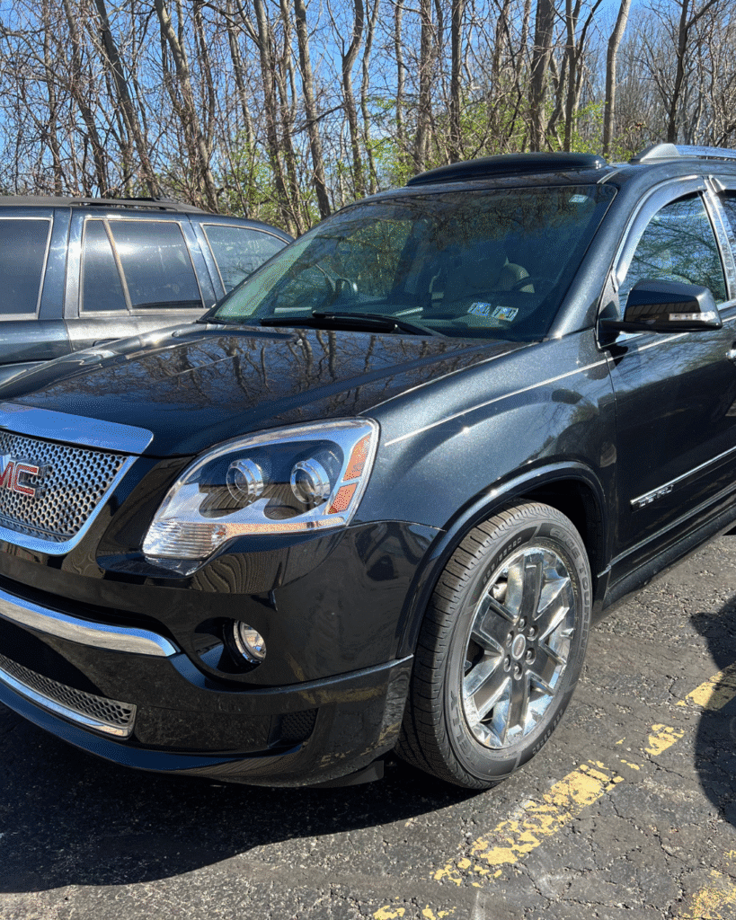 Black GMC Acadia parked outdoors, after receiving body repair services.