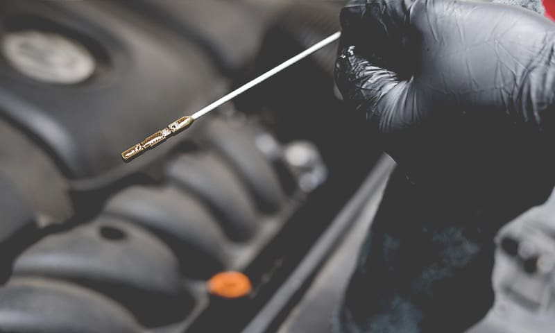 An engine's oil being checked with a dipstick, as part of engine diagnostics, as 